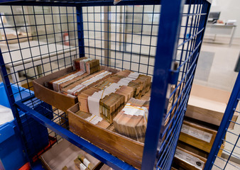 Bundles of cash in boxes in metal secured cage