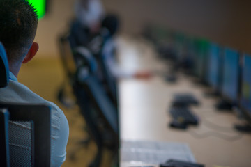 Obraz premium Security guard monitoring modern CCTV cameras in a surveillance room.