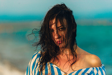 Close up of carefree girl looking at camera at tropical beach