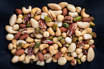 Almonds,Cashews,Macadamias,Pistachios,Brazil Nuts,Hazel nuts,Pecans isolated on black Background close up.