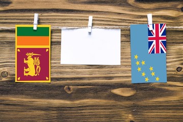 Hanging flags of Sri Lanka and Tuvalu attached to rope with clothes pins with copy space on white...