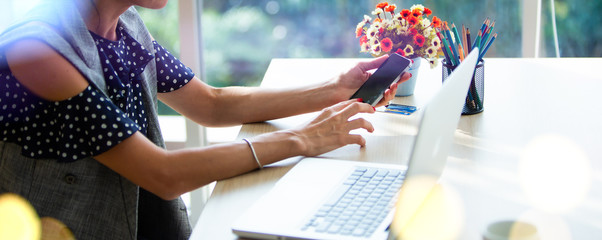 online shopping concepts. Woman hand  holding mobile phone and credit card with Payment Detail page display. using smartphone and laptop computer for online shopping