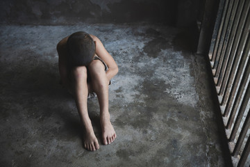  child hug her knee on floor, while sitting alone in cage was imprisoned make no freedom,Violent...