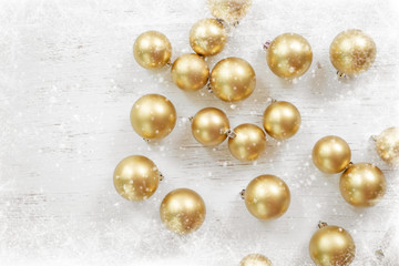 Christmas ball gold decorated on a white wooden with snowflakes. Merry Christmas and winter holiday background. top view.