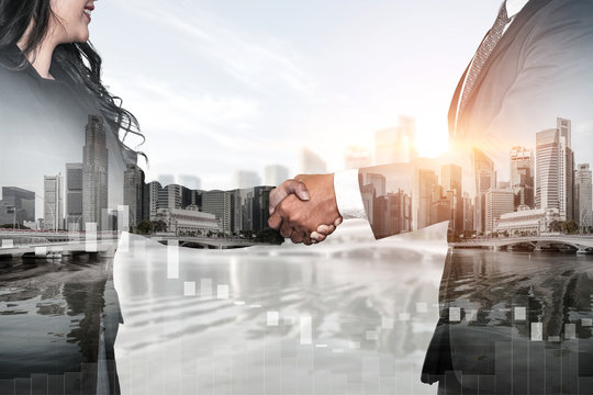 Double exposure image of business people handshake on city office building in background showing partnership success of business deal. Concept of corporate teamwork, trust partner and work agreement.