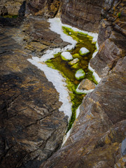 Picturesque granite boulders and green algae on the coast of the Crozon Peninsula. Brittany. France