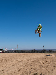 Motocross race bikers jumping and driffting on sand road