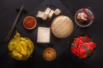 Fermented red and yellow hot peppers with tofu on a black table - traditional Korean food. Top view