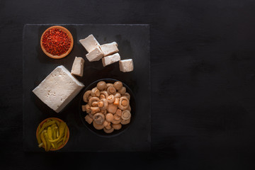 Fermented mushrooms with tofu on a black table - traditional Korean food. Top view. Copy space