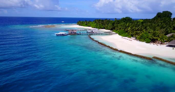 tropical atoll island on Maldives, overwater bungalows , beachfront swimming pool and restaurant, luxury vacation concept