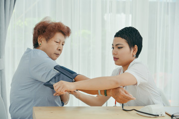 Fototapeta premium Asian doctor checking up her patient old woman in office.