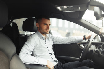 Conversations and phone calls, negotiations. Portrait of a young successful man in the car.