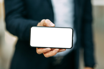  Business blank for the designer. Phone with a white screen in the hands of a man.