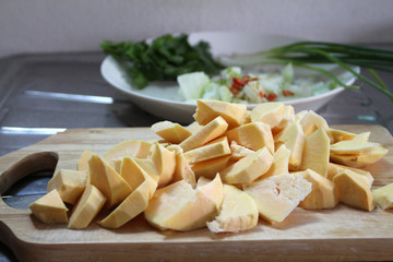 slices of sweet potatoes on chopping board with other ingredient