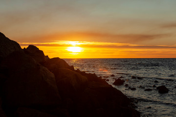 Afternoon sunsetting over Port Phillip bay rocky cliff side.
