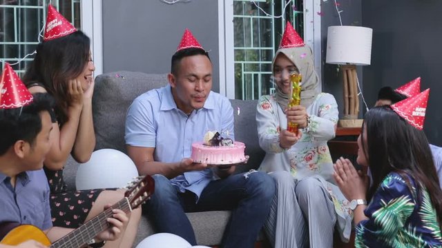Group of friends enjoying brithday party and singing together