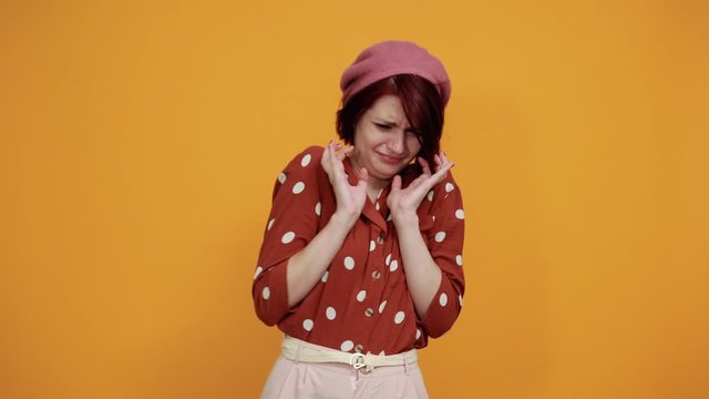 Beautiful young woman wearing red shirt in white polka dot over isolated background, displeased and fearful doing disgust face because aversion reaction. With hands raised. Annoying concept.