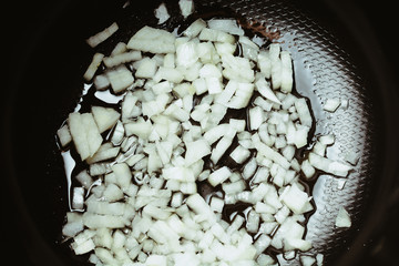 Sliced onions in slow cooker for stewing and frying.