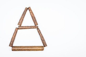 Triangular house of twisted cigars on white background.