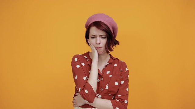 Beautiful young brunette bored girl wearing red shirt with white polca dot over isolated background. Thinking looking tired and bored with depression problems with crossed arms.