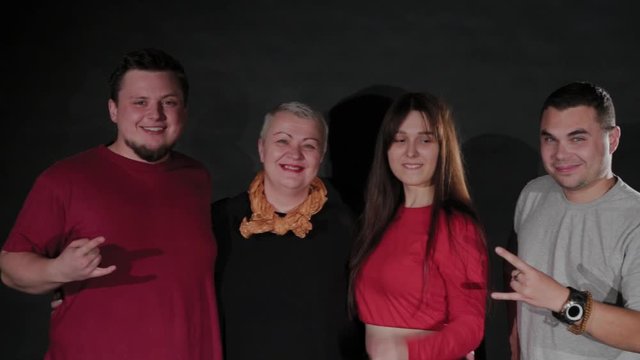 An elderly woman a young girl and two guys hug and laugh. Happy friends.