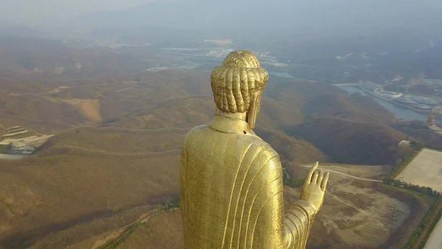 View from the side of Spring Temple Buddha and the temple at it's feet in Lushan County, Henan, China (aerial photography)