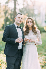 Autumn wedding in European style. Beautiful couple in suit and white dress in Park.