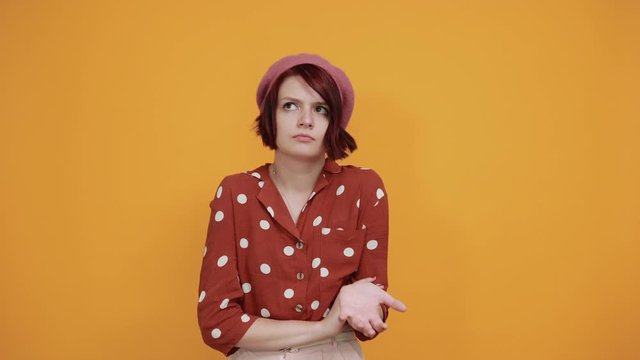 Beautiful young brunette bored girl wearing red shirt with white polca dot over isolated background. Thinking looking tired and bored with depression problems with crossed arms.