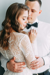 Stylish wedding in European style. Beautiful couple celebrating and drinking champagne in the Studio.