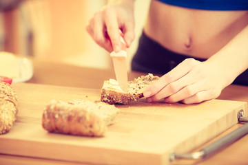 Woman making sandwich cutting bread