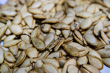 Baked organic pumpkin seeds background, ready to eat.