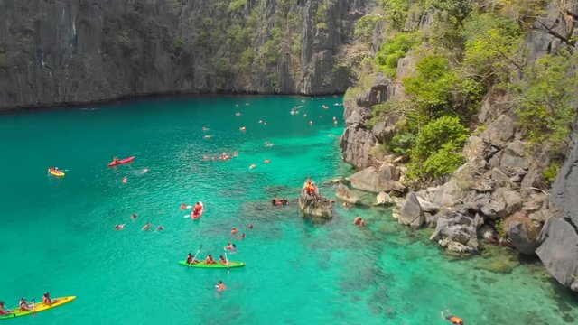 People kayaking in the twin lagoon between the rocks in Coron, Palawan, Philippines.