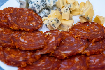 Appetizer with beer and wine. Sliced cheese with mold and salami Chorizo sausage