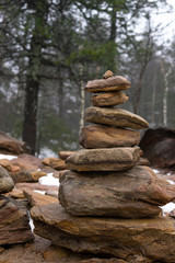 Cairn Building in winter forest. Close up. Vertical