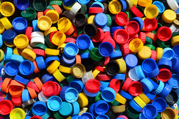 Plastic bottle caps background. Cap material is recyclable.Remove lids from plastic bottles before recycling them. Recycling collection and processing plastic bottle caps