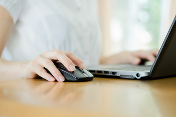 Image of female hands clicking computer mouse