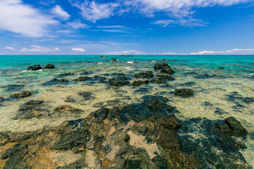 tranquillity and silence , abandoned beach with azure water, rocks on coast, beautiful turquoise sea with mild surf, deep blue sky with clouds and mountains on background, Mediterranean landscape
