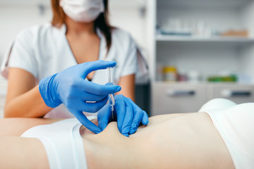 Cosmetician gives botox injection in the stomach