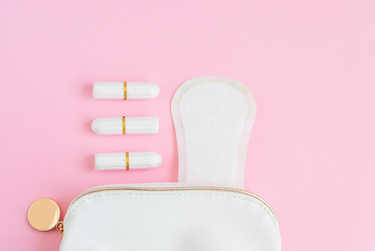 tampons and menstrual pads in a cosmetic bag on a pink background. woman period concept.