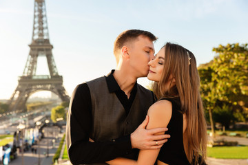 Romantic couple kissing near the Eiffel tower. Love, date, honeymoon in Paris