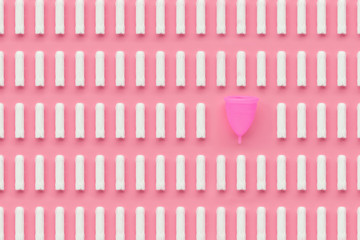 Menstrual cup and tampons on pink background. Alternative feminine hygiene product during the period. Women health concept. Copy space. Eco friendly concept, zero waste product. Flat lay, template