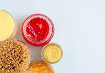 body brush and skin care cream  on a pink pastel background