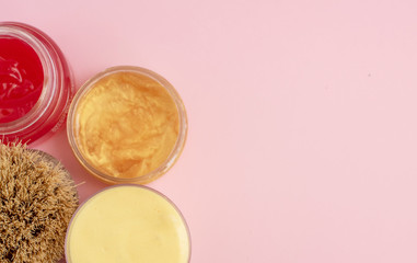 body brush and skin care cream  on a pink pastel background