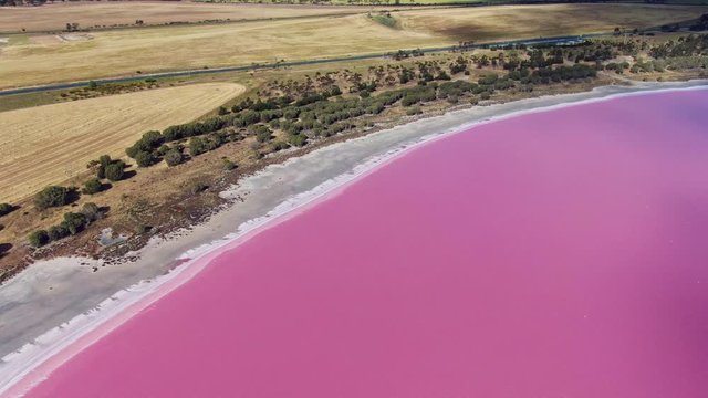 Aerial high angle drone view footage of Loch Iel, also called Pink Lake, near the village of Dimboola in Victoria, Australia. The pink color results from red pigment secreted by microalgae in summer.