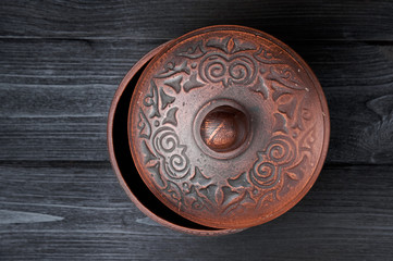 brown clay pan on a black wooden background