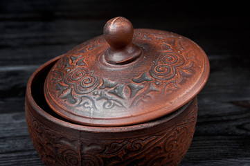 brown clay pan on a black wooden background