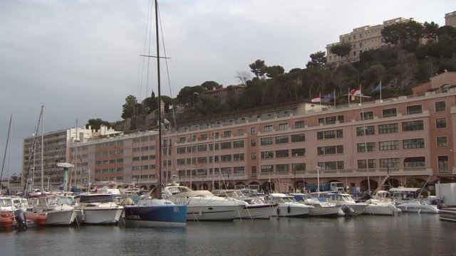 Sailboats moored in sea at harbor by building against sky - Monte Carlo, Monaco