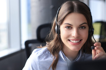 Female customer support operator with headset and smiling.