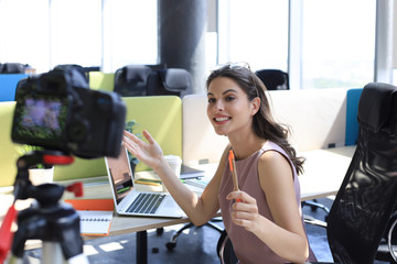 Beautiful young woman talking and smiling while making new video for her blog.
