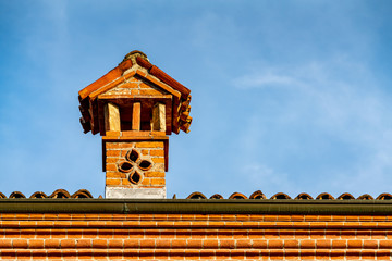 Red roof and brick chimney of a old house in Italy